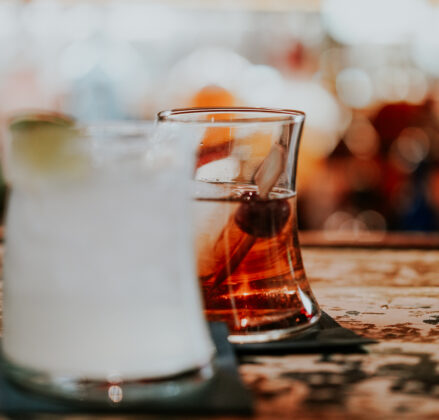Two cocktails sitting on bar
