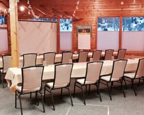 A meeting room with several tables and chairs