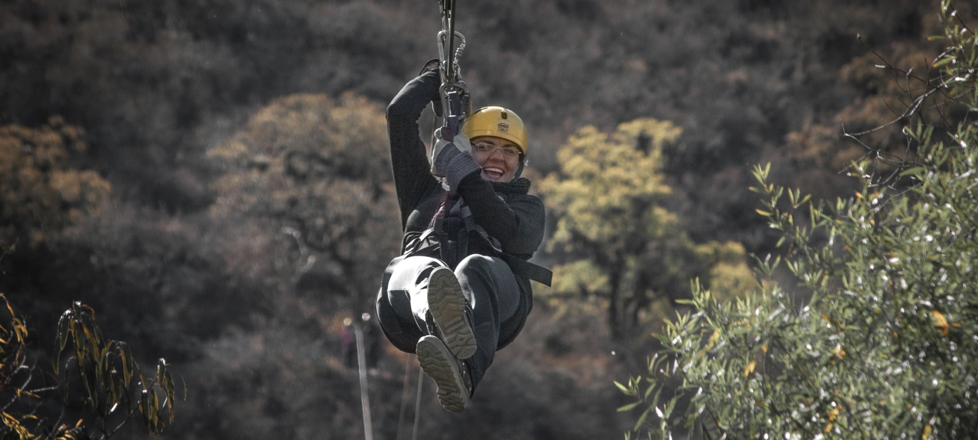 Person smiling and riding on a zipline