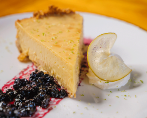 Cheesecake with a blueberry reduction garnish and whipped cream