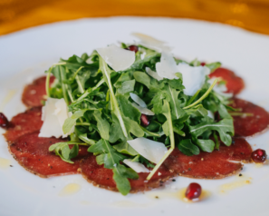 Arugula salad atop a thin layer of prosciutto