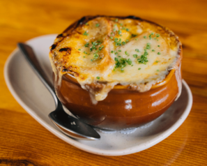 a bowl of french onion soup with a thick layer of melted cheese on top