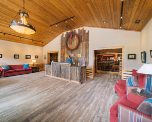 Large room with red, rustic decor and a front desk made with reclaimed wood